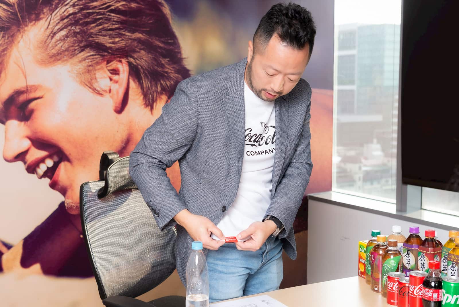 台灣可口可樂總經理陳正峰身穿以100％再生塑料製成的可口可樂 T 恤，說明再生材質可製成的產品多元豐富，因此可口可樂在各方面也都會致力使用再生材質。